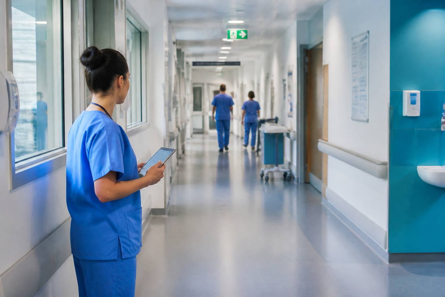 Healthcare professional reviewing information in a hospital corridor